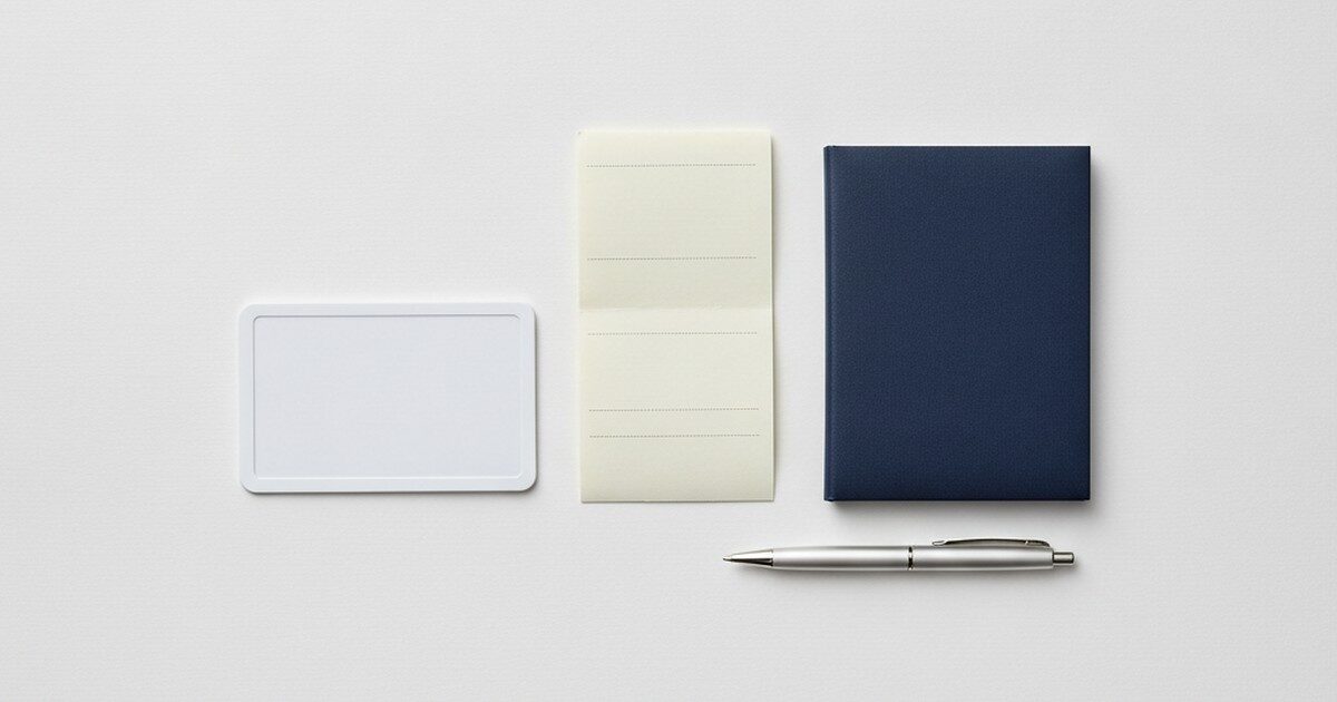 A blank ID card, pay stub, and checkbook arranged on a desk